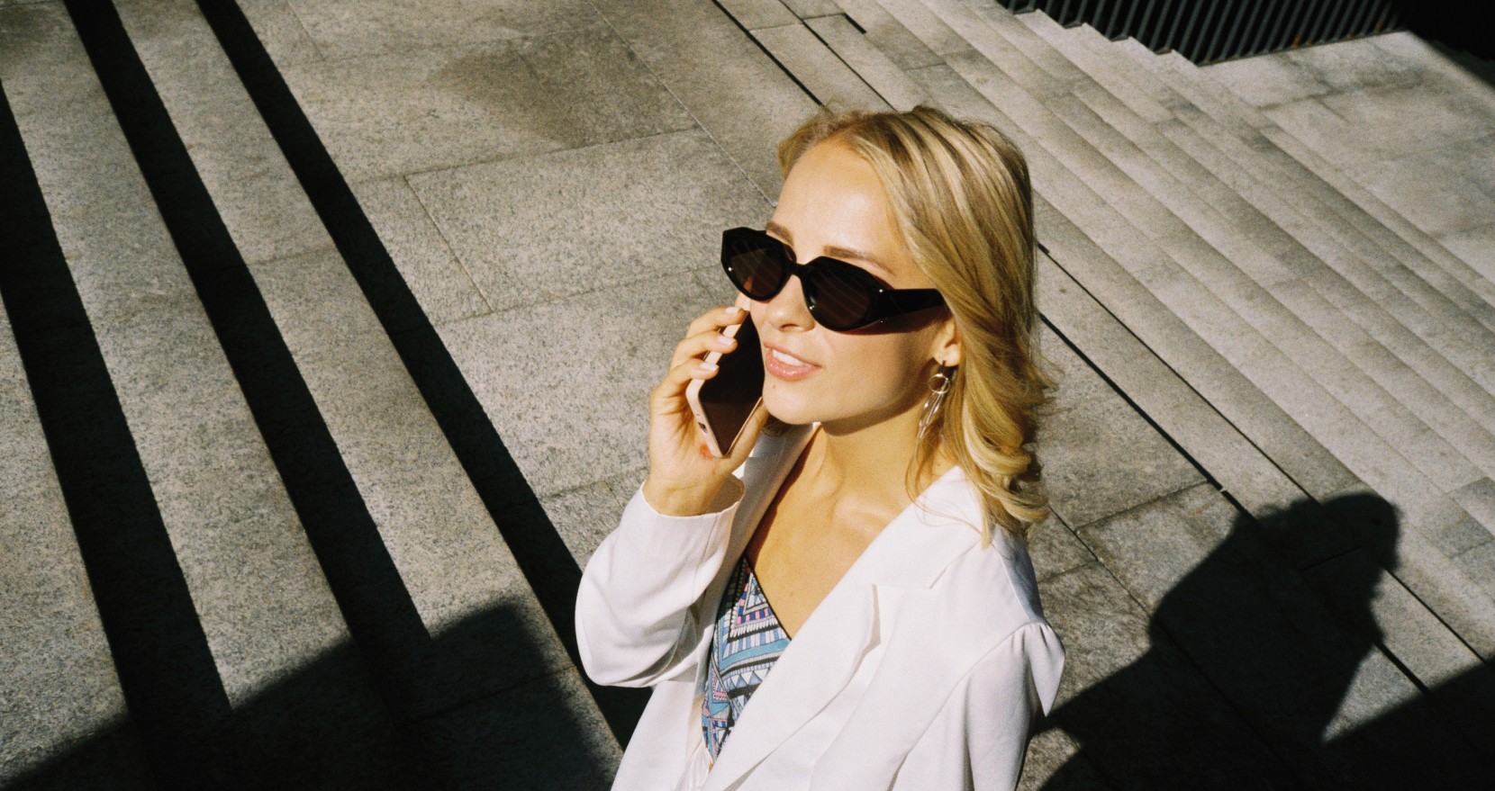 Stylish young woman on the phone, wearing sunglasses